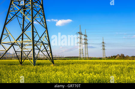 Pylônes électriques dans un champ de canola Banque D'Images