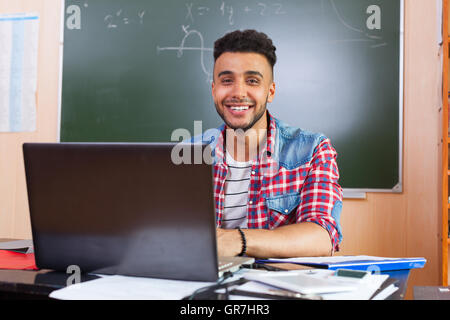 Hispanic Man Using laptop computer, étudiant à l'Université de classe au Bureau plus de déficience Banque D'Images