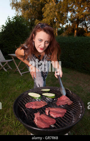 Femme sur le BBQ Banque D'Images