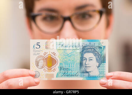 Curator Jenni Adam est titulaire d'un nouveau polymère 5 pound note à l'ouverture de la nouvelle galerie à la Banque d'Angleterre, Londres, Musée sur l'histoire du billet. Banque D'Images