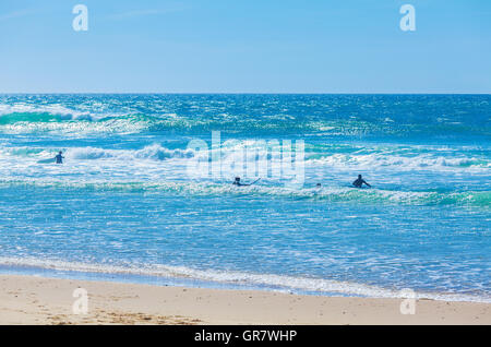 Silhouettes de surfeurs sur les vagues de l'océan Atlantique près de Biarritz, France Banque D'Images