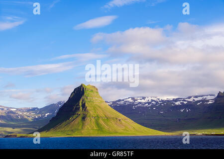 Kirkufell montage vu de la montagne de forme conique et au large, sur la côte nord de la péninsule de Snæfellsnes en été. L'Islande Banque D'Images