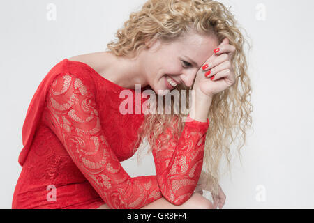 Rire d'une jolie jeune femme en robe rouge Banque D'Images