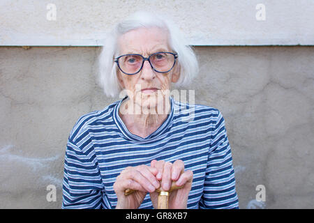 Soutenir les femmes âgées sur une canne à l'extérieur Banque D'Images