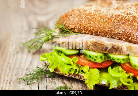 Close-up de savoureux sandwich au pain de seigle avec un rôti de viande et légumes, sur fond de bois Banque D'Images