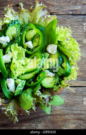 Salade de légumes verts mixtes organiques de feta dans bol en bois close up Banque D'Images