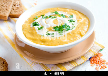 Crème de pois chiches et de la soupe au fromage à la crème et le persil dans un bol sur fond de bois rustique Banque D'Images