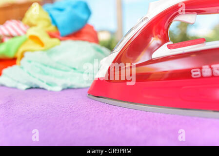 Fer à repasser et tas de vêtements pour le repassage. Banque D'Images