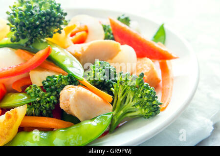 Des légumes sautées avec du poulet sur plaque blanche close up Banque D'Images