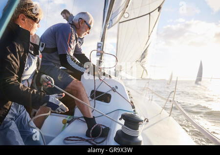 Couple de retraités de la voile en tirant sur le gréement voilier Banque D'Images