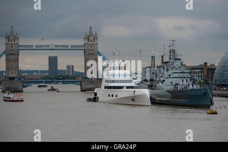 A 390ft motor yacht de tycoon russe Andrey Melnichenko, aux côtés de HMS Belfast (à droite) sur la Tamise à Londres. Banque D'Images