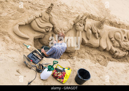 L'homme travaillant sur l'artiste sculptures en sable avec de l'équipement par le côté de la Tamise à Londres en septembre Banque D'Images