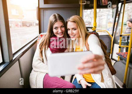 Belles jeunes femmes voyageant par autobus, en tenant selfies Banque D'Images