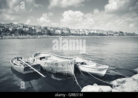 Retro photo stylisée dans les tons bleus de trois anciens bateaux de pêche en bois amarré à petit port d'Avcilar, Istanbul, Turquie Banque D'Images