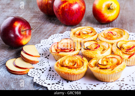 Roses en forme de pomme muffins sur table en bois rustique. Apple pie dessert sucré. Pâtisserie maison rose apple. Banque D'Images