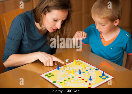 Mère et fils jouer jeu ludo à la maison. Banque D'Images