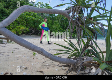 Femme marche sur Snorkeller Plage de sable blanc de la mer vers Banque D'Images