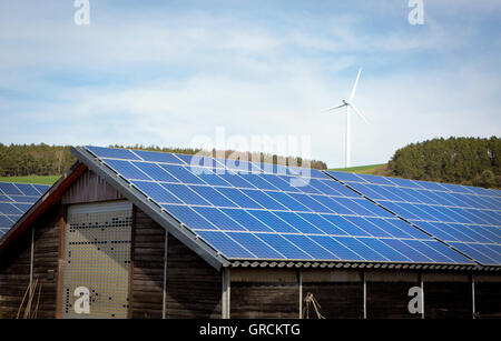 Propriété agricole avec système photovoltaïque, éolienne en arrière-plan Banque D'Images