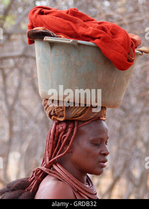 Femme Himba Seau avec laverie sur sa tête, la Namibie Banque D'Images