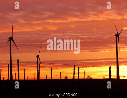 Éoliennes contre Fiery Red Sunrise Banque D'Images