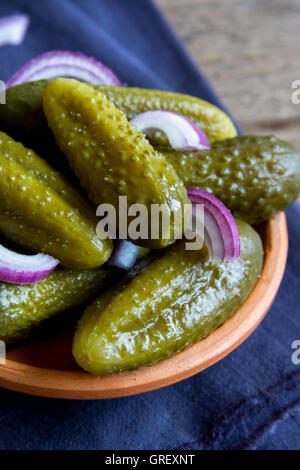 Cornichons dans Bol en céramique sur fond en bois rustique, Close up Banque D'Images