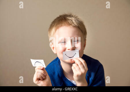 Jeune garçon (adolescents) sélectionnez entre les expressions positives et négatives Banque D'Images