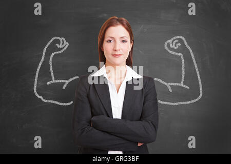 L'anayse confident businesswoman avec muscles dessinés à la craie sur un tableau noir Banque D'Images