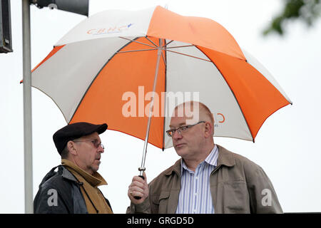 Les spectateurs à l'abri de la pluie sous les parasols que la pluie retarde le début de jouer - Essex Eagles vs Surrey Lions - Les Amis de la vie T20 Cricket la Ford Comté Rez, Chelmsford - 24/06/11 Banque D'Images