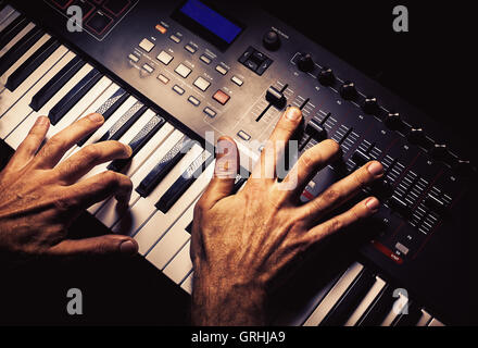 Détails d'un clavier midi moderne avec des mains jouant sur elle. Banque D'Images