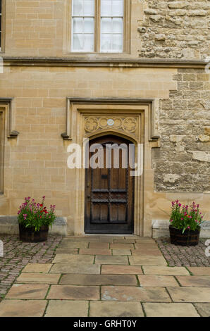 L'ancienne porte de bois dans une cour au Trinity College, Oxford, Royaume-Uni Banque D'Images