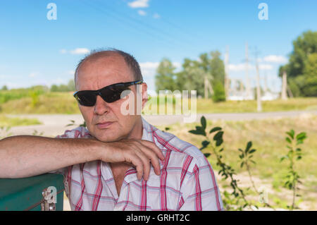 Outdoor portrait of mature woman in black lunettes Banque D'Images