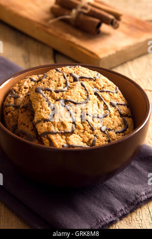 Des biscuits avec du chocolat dans la tasse sur fond de bois rustique Banque D'Images