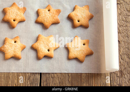 Gingerbread cookies faits maison (étoile) sur du papier sulfurisé et table en bois rustique Banque D'Images