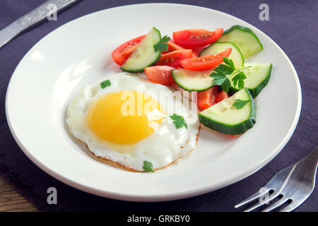 Œuf frit avec une salade de légumes frais sur la plaque pour le petit déjeuner Banque D'Images