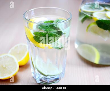 Fresh boisson non alcoolisée avec de l'eau, les feuilles de menthe, pièces de citrons et limes en verre. Banque D'Images