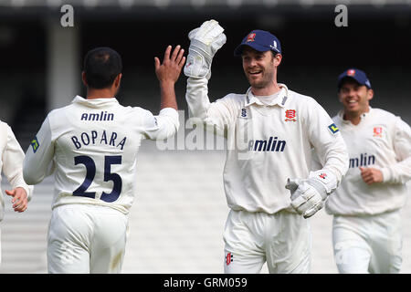 Ravi Bopara d'Essex est félicité par le capitaine James Foster (C) après son lancer à court Rory Burns - Surrey CCC vs Essex CCC - LV County Championship Division Two de cricket au Kennington Oval, Kia, Londres - 22/04/14 Banque D'Images