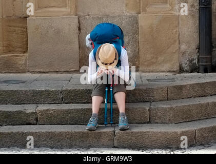 Un pèlerin moderne repose sur une place de Santo Domingo de la Calzada, l'Espagne le 26 août, 2016. Photographie d'auteur John Voos Banque D'Images