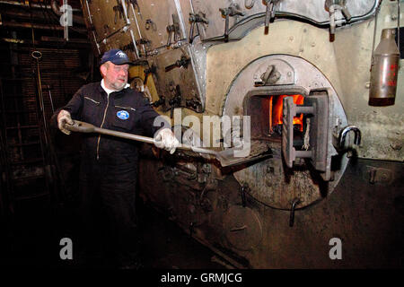 Stoker à pelleter du charbon dans la chaudière à vapeur 'Stettin, brise-glace' sur sa façon de Hambourg à Kiel, Schleswig-Holstein, Allemagne Banque D'Images