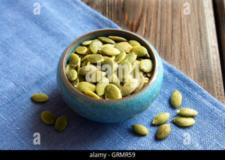 Les graines de citrouille dans bol bleu close up Banque D'Images