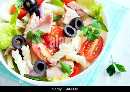 Salade de pâtes au thon et tomates fraîches, olives, herbes close up Banque D'Images