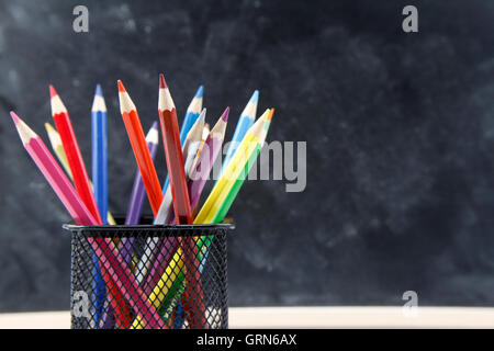 Crayons de couleur in front of blackboard Banque D'Images