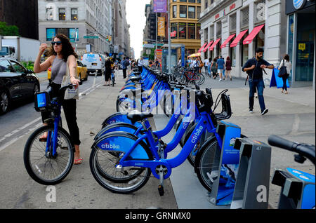 Une femme sur un pilote par un Citibike Citibike partager gare à Union Square.Manhattan.New York City, USA Banque D'Images