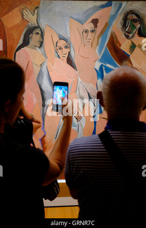 Les Demoiselles d'Avignon (1907) de Pablo Picasso avec ses visiteurs utilisent un téléphone portable pour prendre des photos au Musée d'Art moderne (MoMA).Manhattan, New York, Etats-Unis Banque D'Images