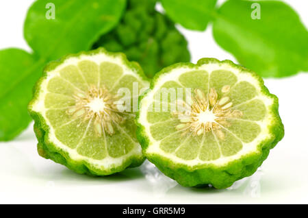 Fruits et feuilles vertes de chaux ou chaux Kiffir Leech (Citrus hystrix DC.) sur fond blanc. Banque D'Images