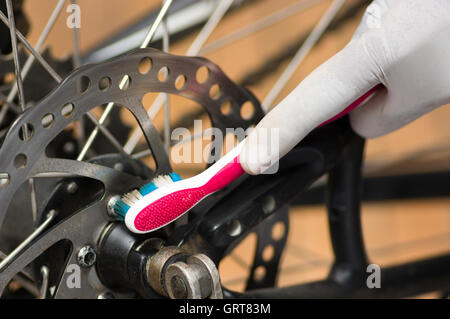 Libre regard détaillé sur le passage de roue de vélo au cours de l'entretien mécanique, réparation des pièces plus de brossage brosse à dents Banque D'Images