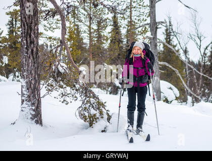 Jeune femme avec un sac à dos de ski en Laponie. Banque D'Images