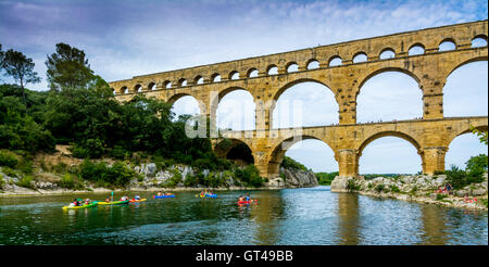Pont du Gard avec kayakistes pagayant sous l'ancien aqueduc dans le Gard, Occitanie, France Banque D'Images