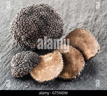 Truffes noires et truffes tranches sur le conseil de graphite. Banque D'Images