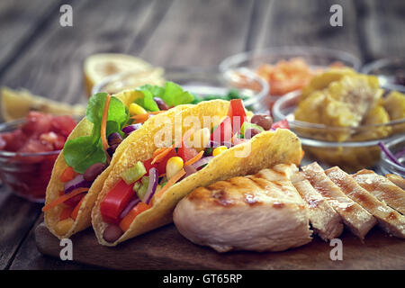 Tacos tortilla de maïs mexicains avec des légumes et du poulet grillé sur fond de bois Banque D'Images