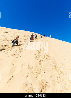 AQUITAINE, FRANCE - 5 avril 2011 : Groupe de touristes marcher sur la plus haute dune d'Europe - Dune du Pyla (PILAT) Banque D'Images